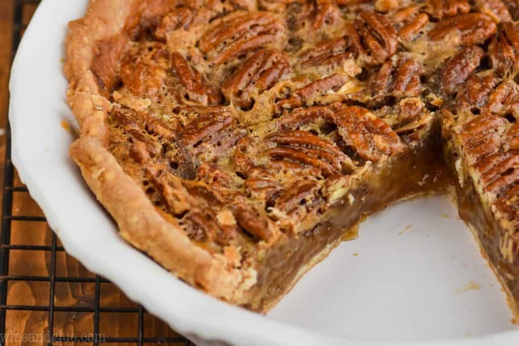 landscape view of a cut into pecan pie, you can see its caramel looking insides