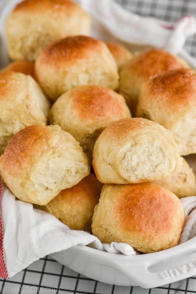 an oval baking dish with a cloth napkin and then piled high with dinner rolls