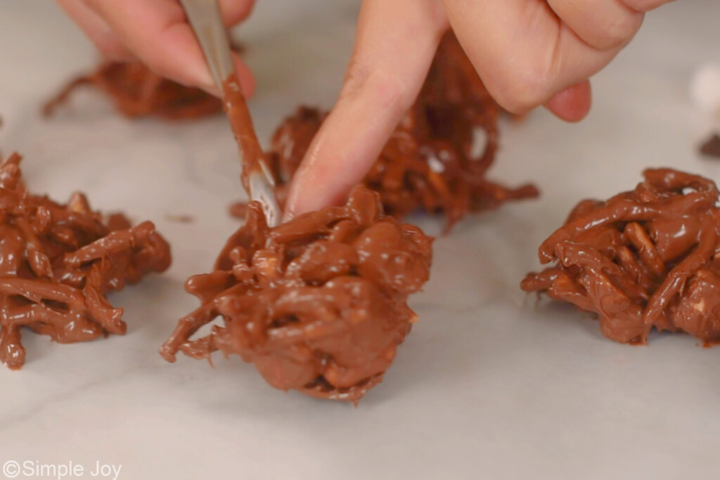 hand spooning out mixture of haystacks recipe