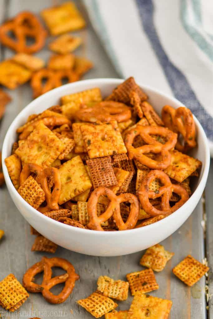 small white bowl full of homemade chex mix recipe on a gray board with a white napkin in the background
