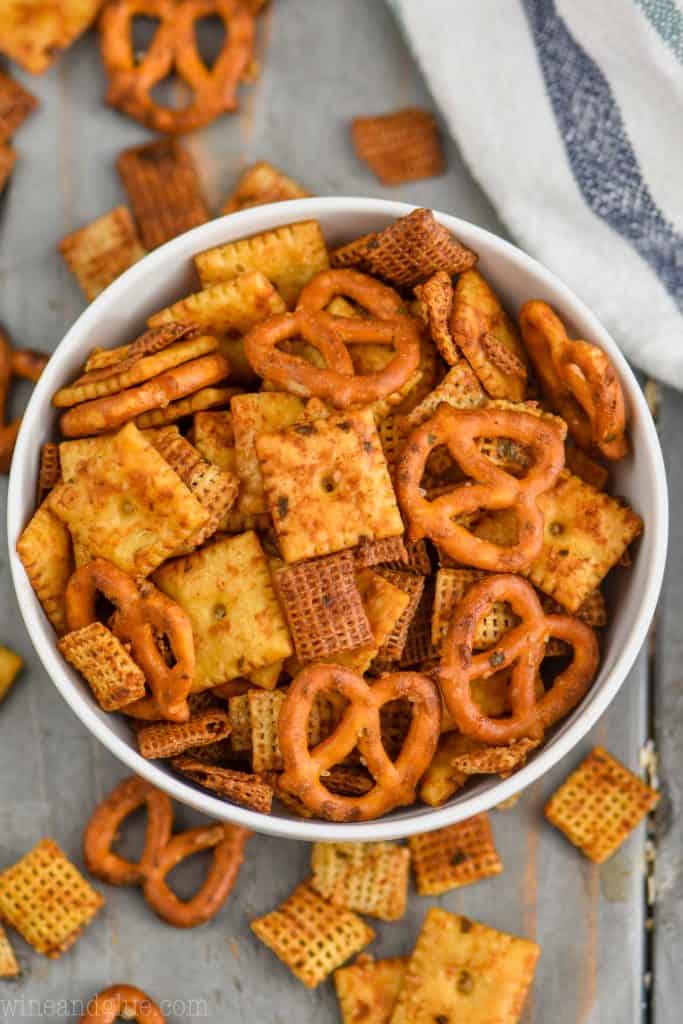 overhead of a white bowl full of chex mix recipe with crackers, cereal, and pretzels