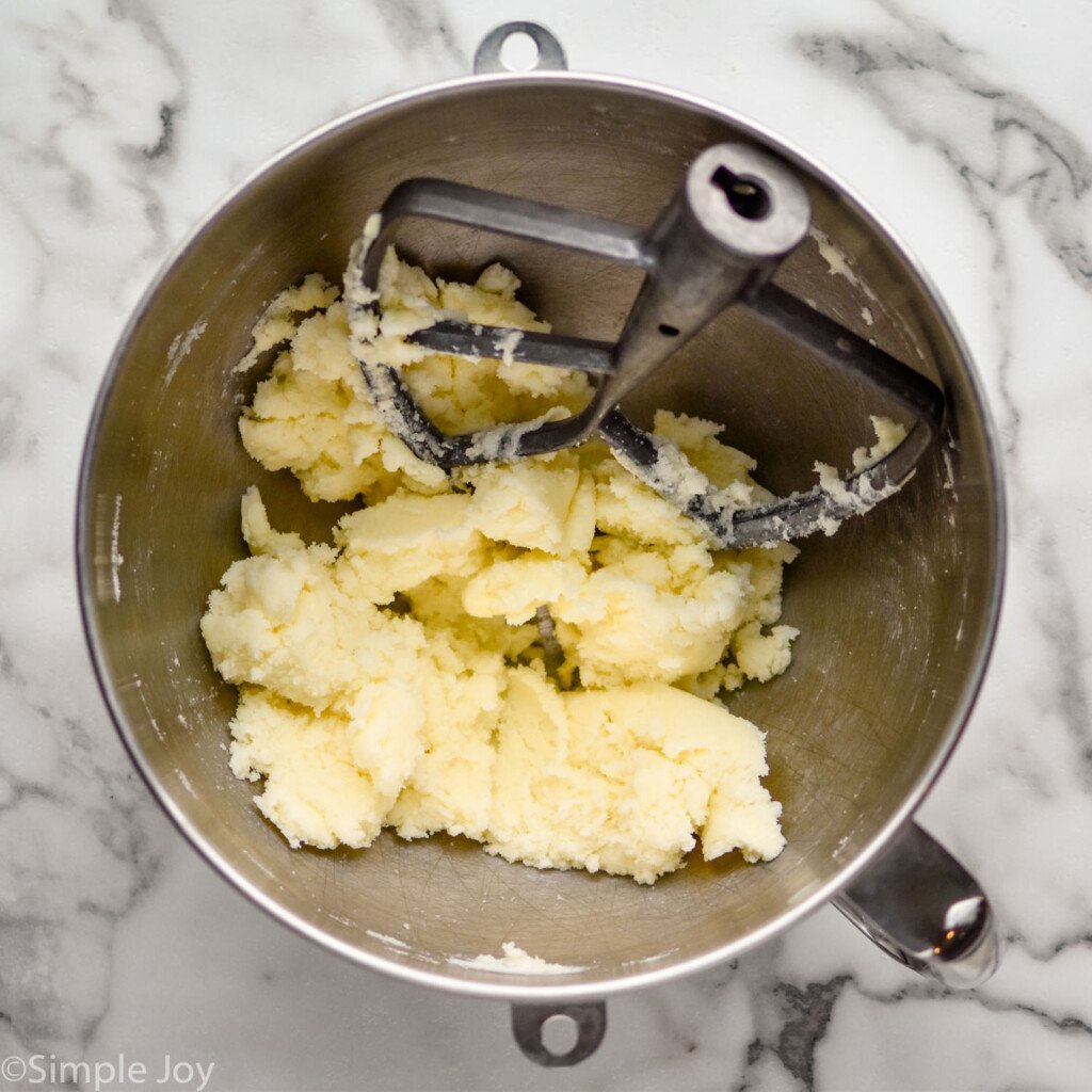 a metal mixing bowl with butter and sugar creamed together