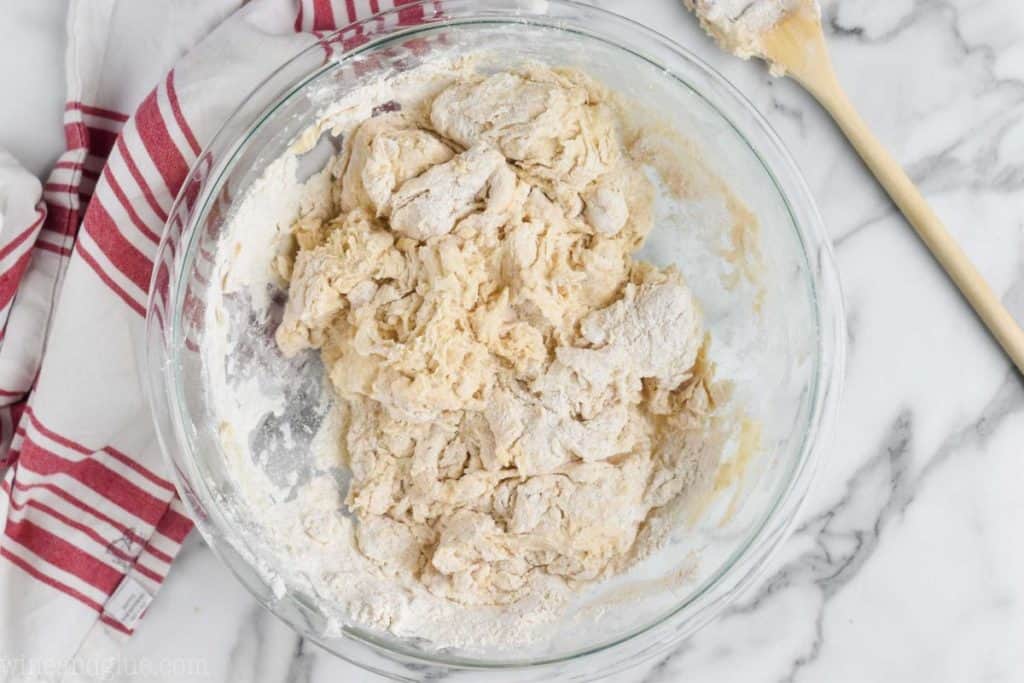 an overhead picture of a bowl of dough just starting to come together