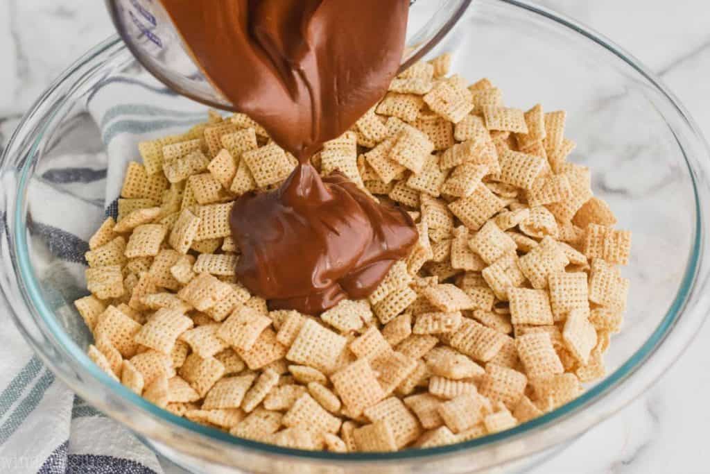 pouring chocolate, butter, peanut butter mixture over Chex cereal to make muddy buddies