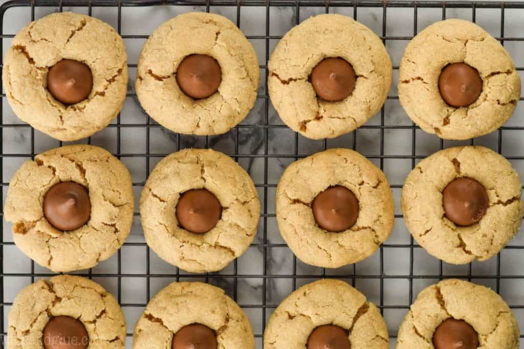 one dozen peanut butter blossom cookies on a wire rack, pictured from overhead