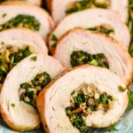 a close up of a piece of stuffed pork tenderloin that has been cooked and sliced, with mushrooms and spinach in the middle