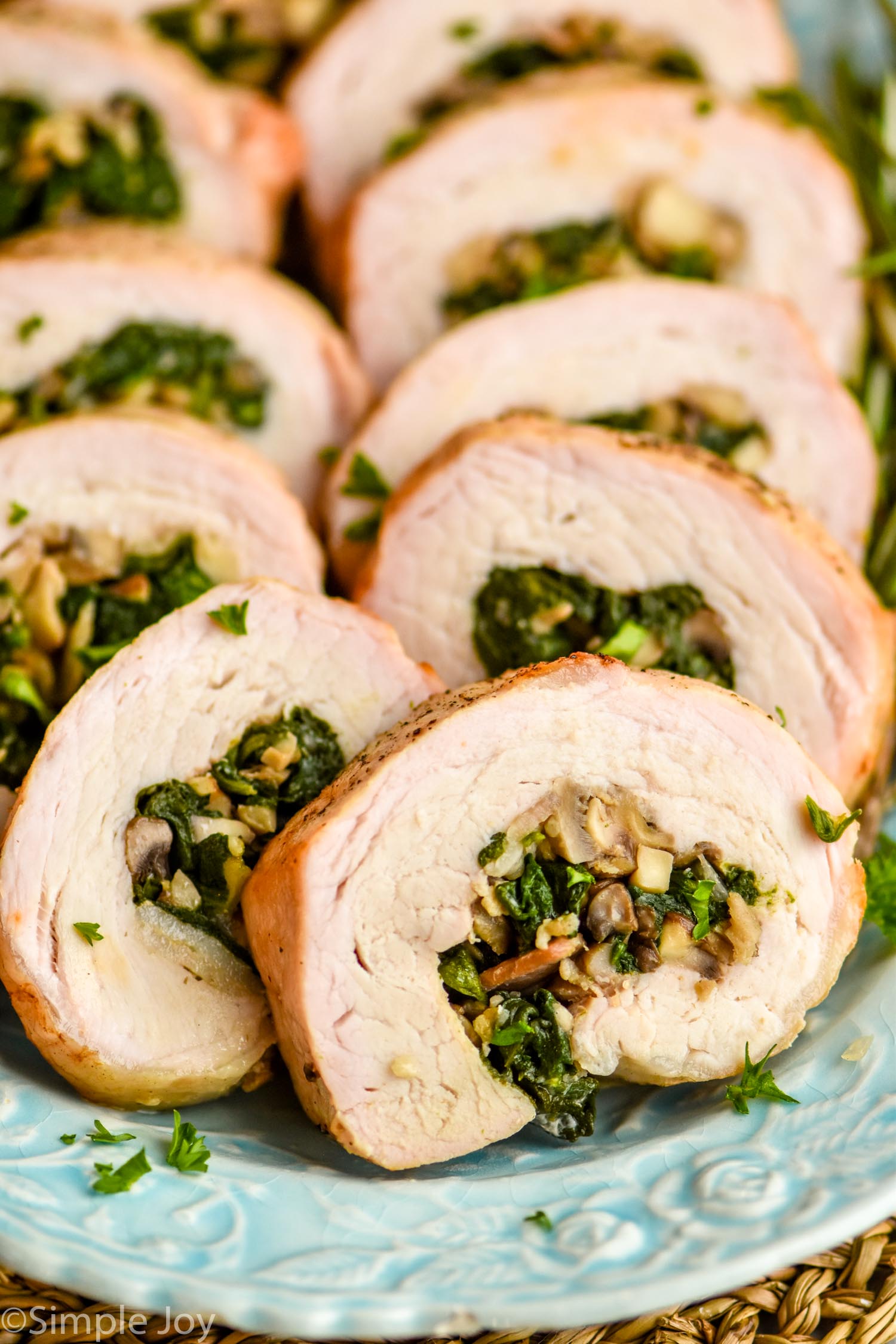 a close up of a piece of stuffed pork tenderloin that has been cooked and sliced, with mushrooms and spinach in the middle