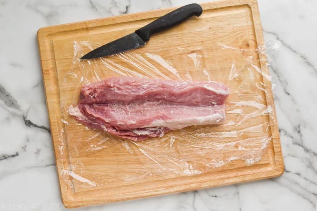 a pork loin that has been butterflied open on a cutting board