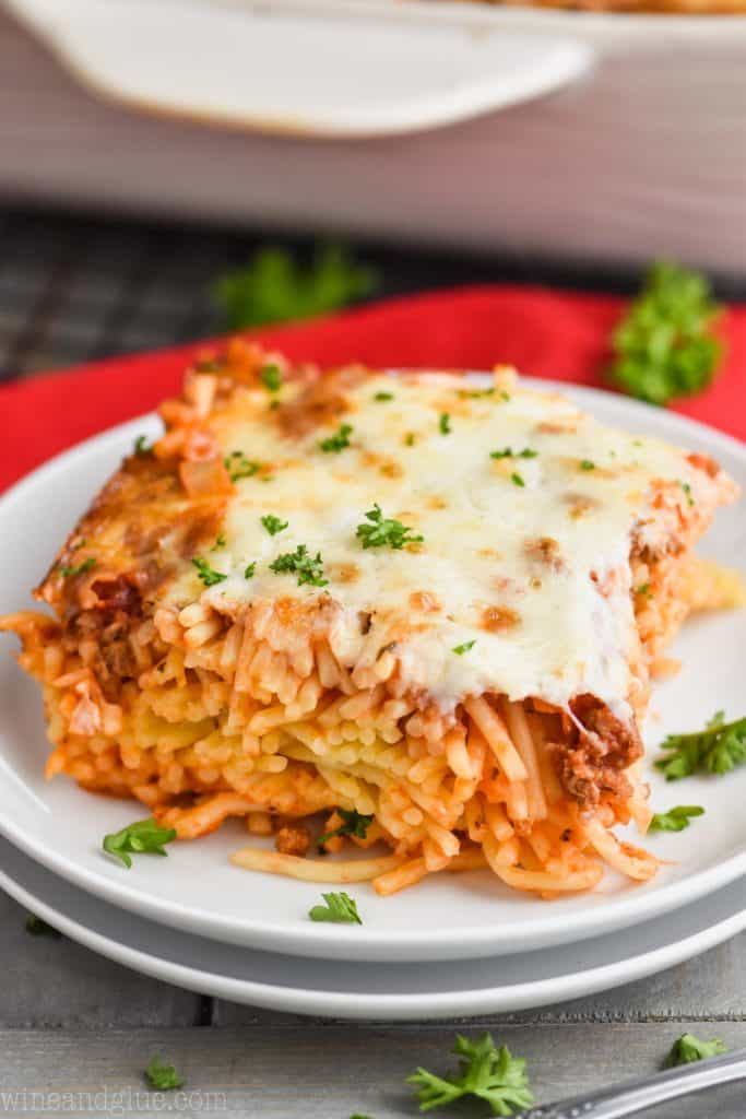 a piece of easy baked spaghetti recipe on a plate with fresh parsley on top