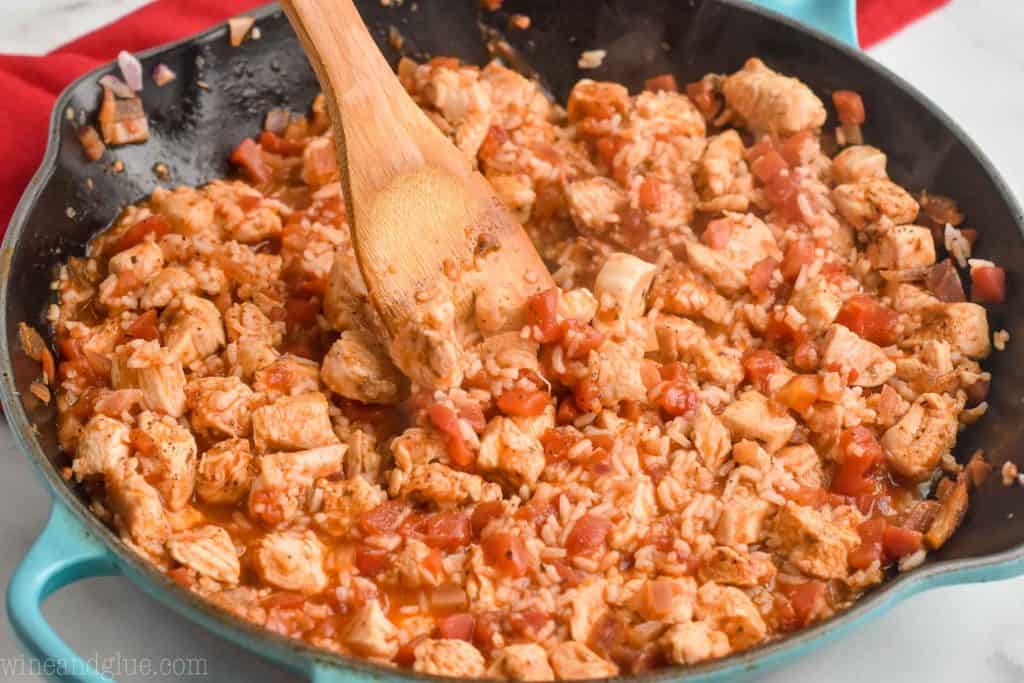 a skillet full of chicken and rice mixture to make chicken stuffed peppers