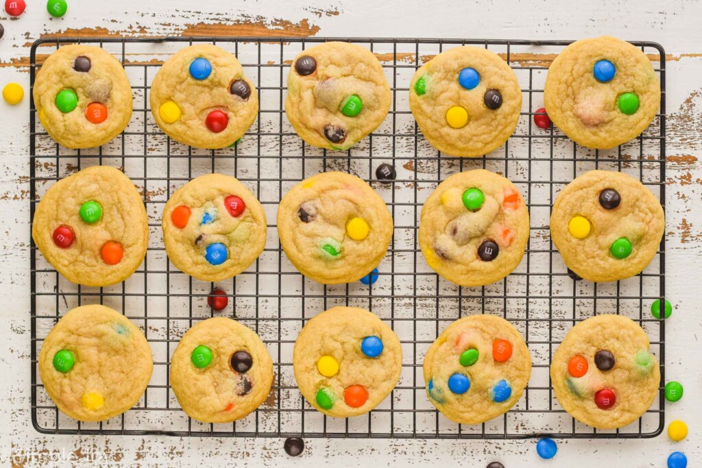 overhead of m&m cookies on a wire cooling rack