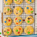 pinterest graphic of overhead of m&m cookies on a wire cooling rack, says: M&M cookies simplejoy.com