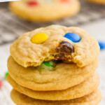 pinterest graphic of stack of M&M cookies recipe with the top cookie missing a bite, says: the best M&M Cookies