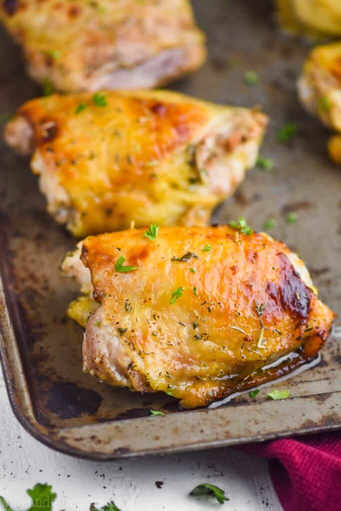close up of a recipe for baked chicken thighs on a baking sheet after it has come out of the oven