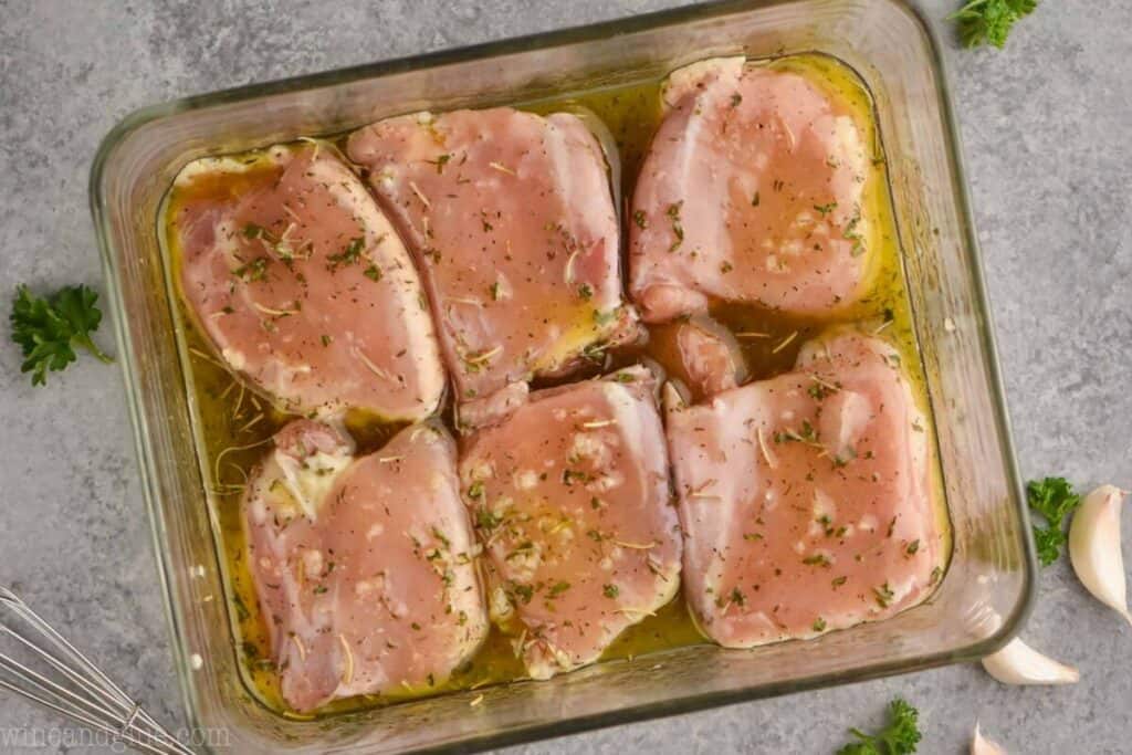 overhead view of boneless skinless chicken thighs in a baking dish, covered in marinade