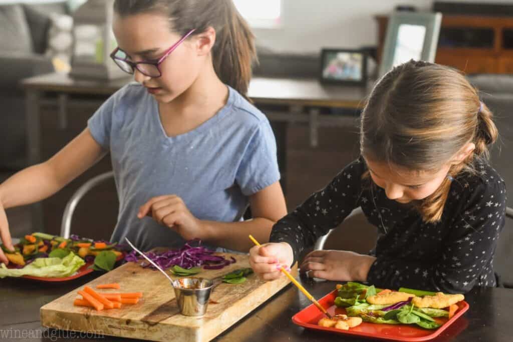 two little girls playing with their food before they eat lunch