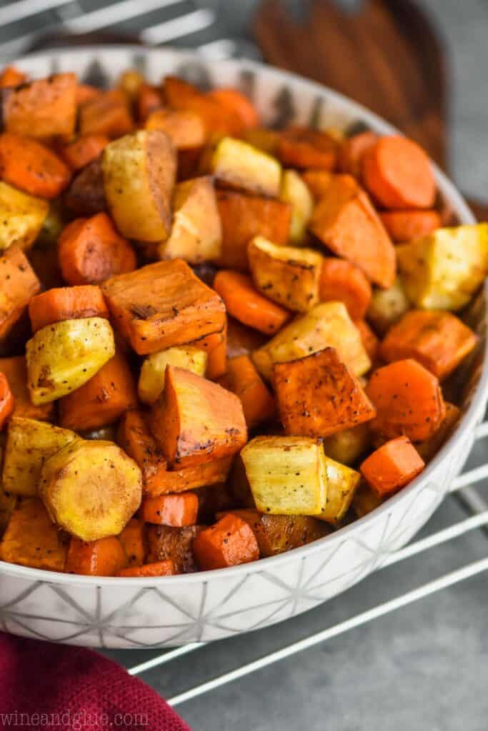 side view of a serving bowl full of oven roasted root vegetables