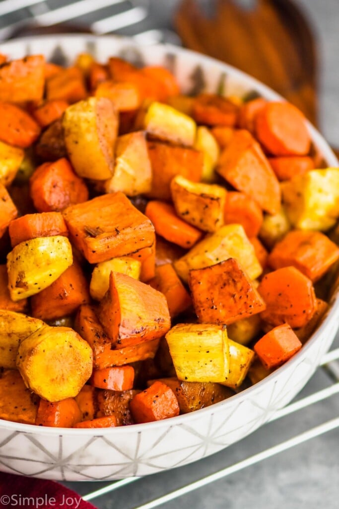 side view of a serving bowl full of oven roasted root vegetables