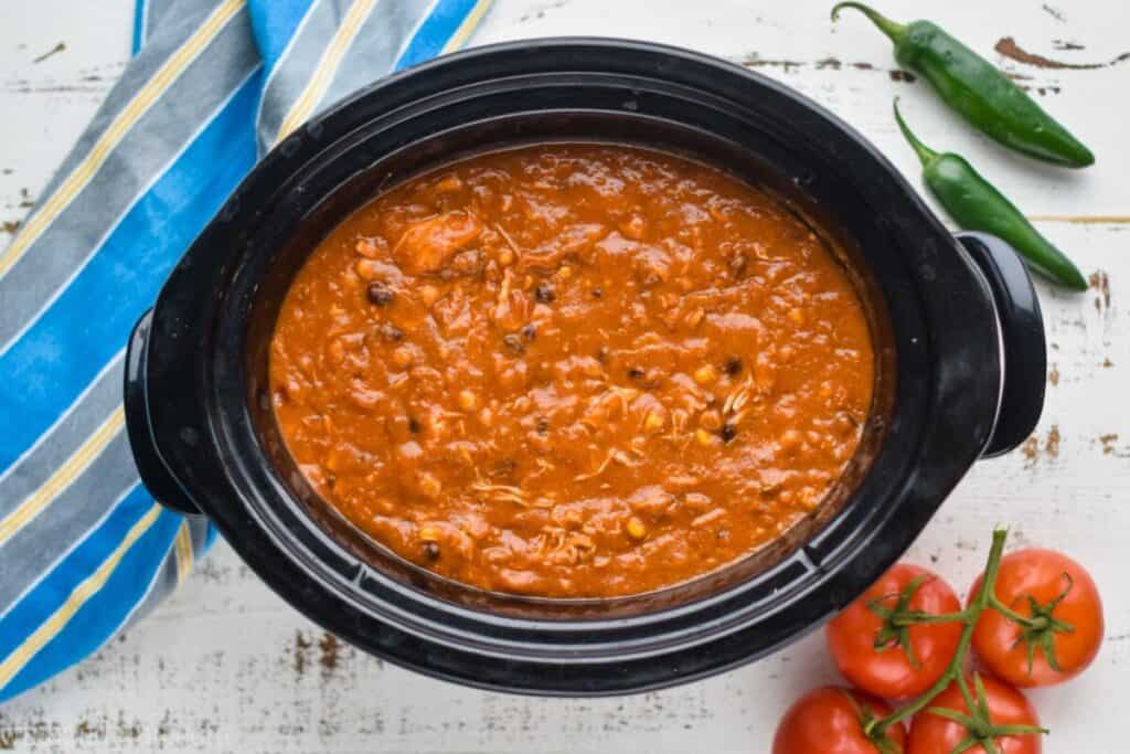 overhead view of a crockpot full of chicken enchilada soup that has been cooked