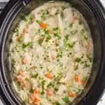 overhead view of a crockpot with chicken and rice casserole garnished with fresh parsley