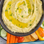 pinterest graphic of overhead of bowl of hummus dip surrounded by vegetables and pita chips, says: hummus recipe simplejoy.com