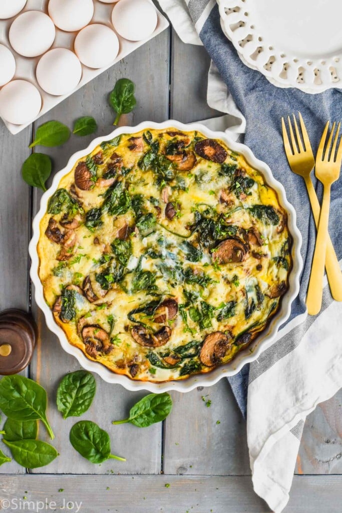 overhead view of a crustless spinach quiche recipe in a white quiche dish