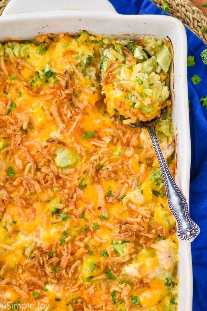 overhead of a casserole dish full of broccoli chicken rice casserole with a serving spoon in it