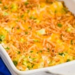 white casserole dish filled with chicken broccoli and rice casserole topped with fried onions