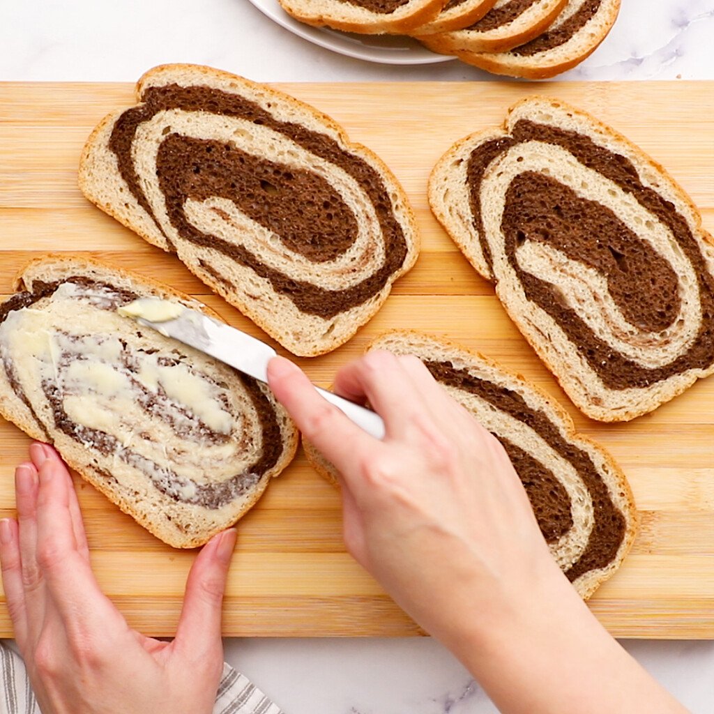 buttering pumpernickel bread