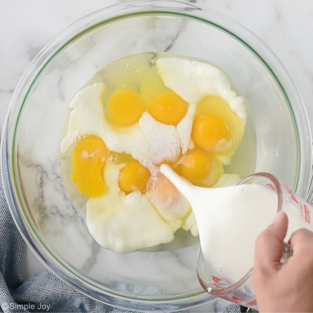 overhead of cream being poured into a bowl of eggs