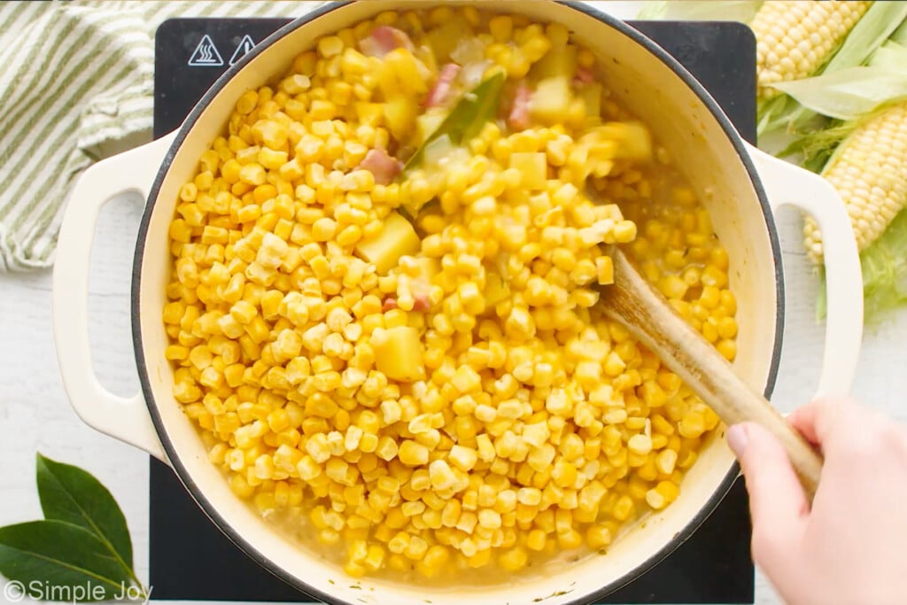 corn being stirred into corn chowder