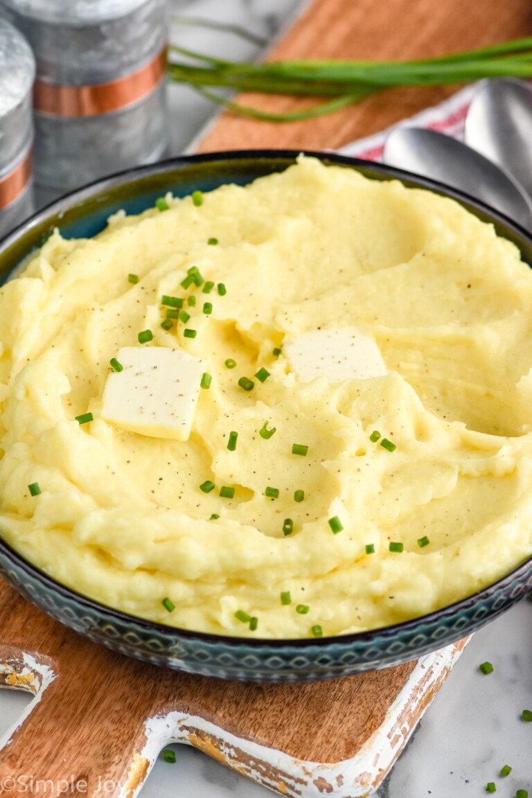 bowl of homemade mashed potatoes topped with butter and chives