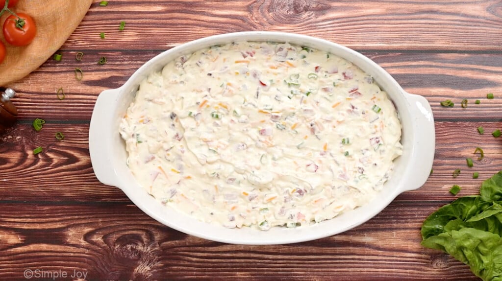 overhead of ingredients for blt dip in a casserole dish before baking