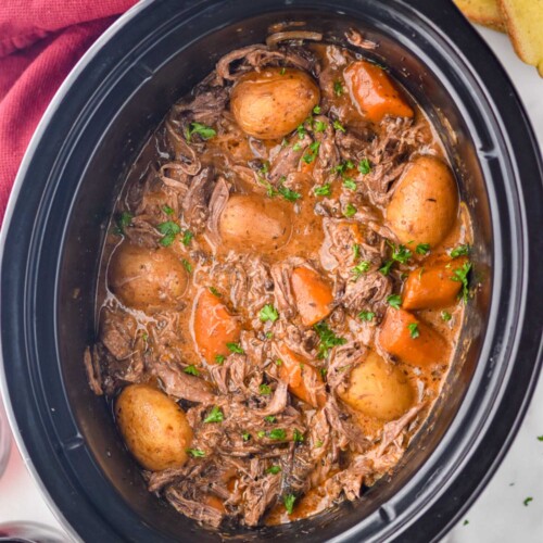 Overhead photo of a crock pot of Slow Cooker Pot Roast recipe.