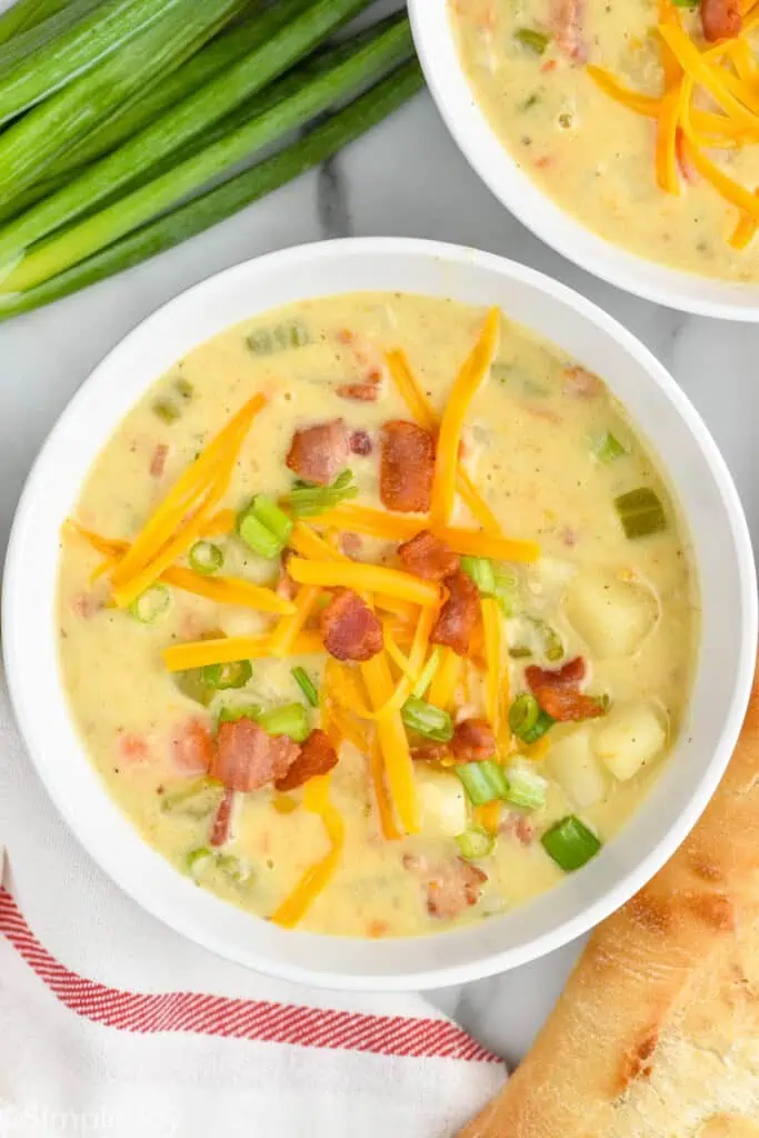 overhead view of easy creamy potato soup with cheese, bacon, and scallions