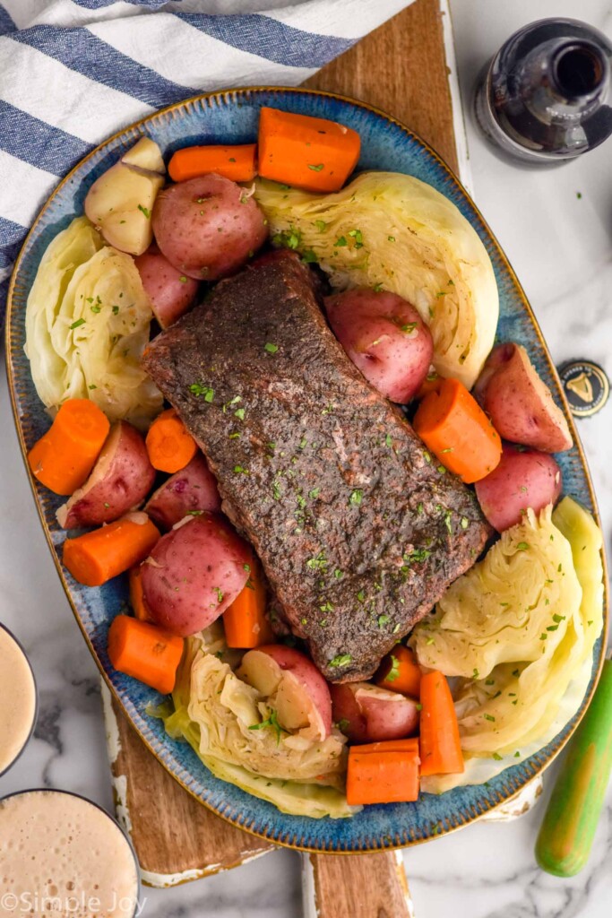 Overhead photo of Instant Pot Corned Beef on a platter with cabbage, potatoes, and carrots