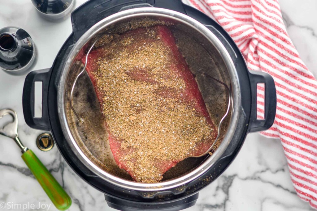 Overhead view of seasoned corned beef in an instant pot for Instant Pot Corned Beef recipe.