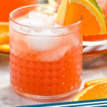 Pinterest graphic for rum punch. Image shows glasses of rum punch with ice and garnished with slice of orange and pineapple wedge. Text says "rum punch simplejoy.com"