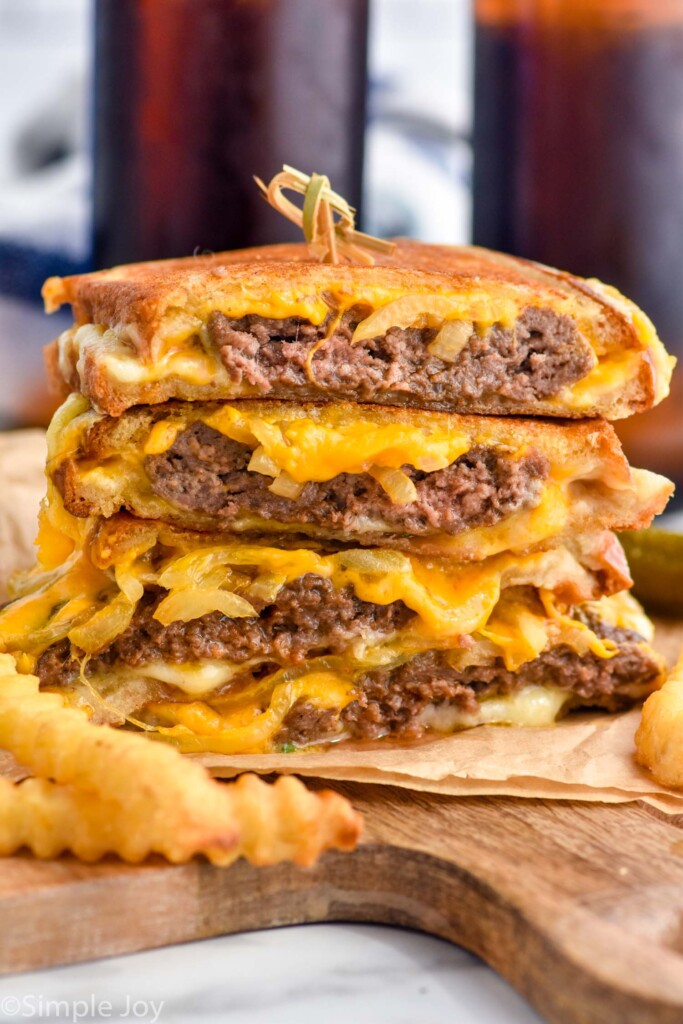 stack of patty melt sandwiches with french fries sitting in front