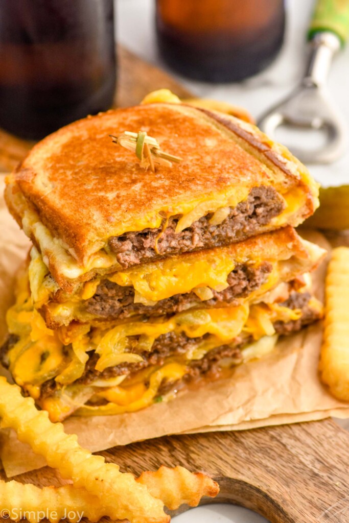 stack of patty melt sandwiches with french fries sitting in front