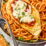 Pinterest graphic for Air Fryer Chicken Parmesan. image shows Air Fryer Chicken Parmesan on a bed of pasta on a plate with a fork. Text says "Air Fryer Chicken Parmesan simplejoy.com"