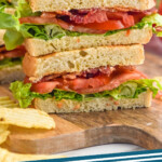 Pinterest graphic for BLT recipe. Image shows a BLT sandwich cut in half and stacked on top of each other with chips beside. Text says, "BLT sandwich simplejoy"