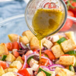 Pinterest graphic for Greek Panzanella Salad. Text says "truly delicious Greek Panzanella simplejoy.com" Image shows glass measuring cup pouring dressing over bowl of Greek Panzanella Salad ingredients.