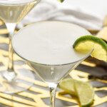Pinterest graphic for Key Lime Martini recipe. Text says, "the best Key Lime Martini simplejoy.com." Image shows a Key Lime Martini garnished with lime slice. Additional lime slices beside.