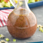 pinterest graphic of close up bottle of red wine vinaigrette with Cobb salad behind it and blue cheese and green onions around it, says: "red wine vinaigrette simplejoy.com"