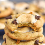 Pinterest graphic for S'mores Cookies recipe. Text says, "the best S'mores Cookies simplejoy.com" Image shows a stack of S'mores Cookies with a bite taken out of the top cookie.