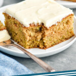 Pinterest graphic for Zucchini Cake recipe. Image shows a piece of Zucchini Cake on a plate with a fork. Text says, "Zucchini Cake simplejoy.com"