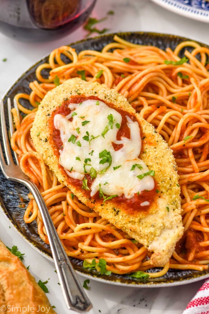 Plate of pasta topped with Air Fryer Chicken Parmesan and a fork