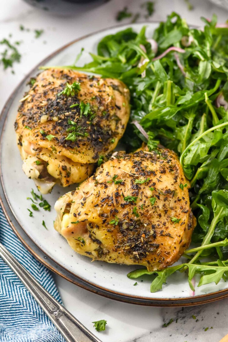 Plate with Crock Pot Chicken Thighs and arugula salad.