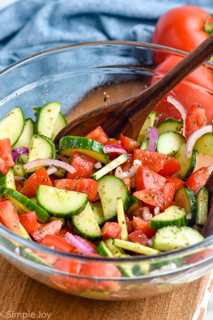 bowl of Cucumber Tomato Salad with spoon for mixing.